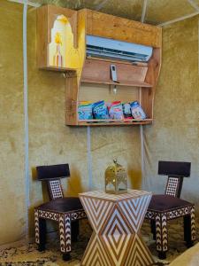 two chairs and a table in a room at Experience Luxury Desert Camp in Merzouga