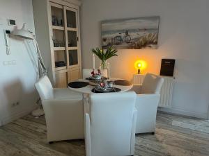 a dining room with a table and white chairs at Le Normandy 5star in Cadzand +37 photos