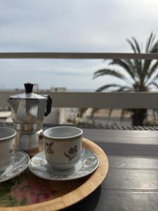 einen Tisch mit zwei Tassen und eine Teekanne auf dem Tisch in der Unterkunft Casa BELLAVISTA tra MARE e TERME in Santa Cesarea Terme