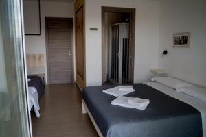 a bedroom with a blue bed with towels on it at Coco'S Rooms in Bari Palese