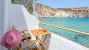 a balcony with a table and a view of the ocean at Giasemi Boathouse in Firopótamos