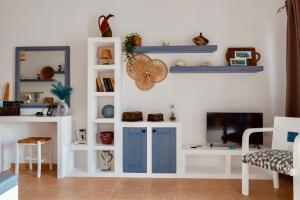 a living room with blue and white shelves and a tv at San Giorgio Leros in Drymonas