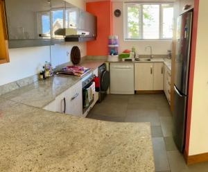 a kitchen with orange walls and a counter top at sea beach pool in Bain Boeuf