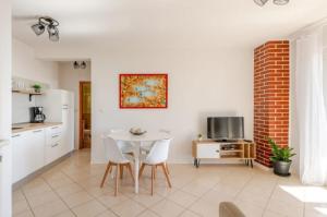 a kitchen and living room with a white table and chairs at Apartments Luma in Hvar