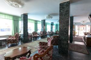a lobby with chairs and tables and windows at Hotel Negresco in Milano Marittima