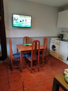 a kitchen with a table and chairs and a tv at Apartamentos La Tarazana 2 in La Pereda de Llanes +7 photos