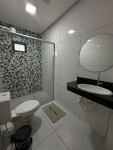 een badkamer met een toilet, een wastafel en een spiegel bij Sol lar hotel flats in Paragominas
