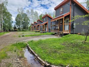 a row of houses on a dirt road next to a yard at The Cozy Caribou - Frontier Village in North Pole