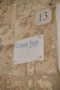 a sign on a stone wall with the number thirteen at Casa Tua - Sea View Chianca in Vieste