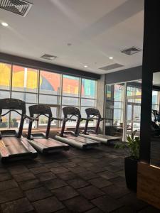 a row of exercise bikes in a gym with windows at The Sky View Apartments in Skopje +15 photos