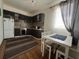a kitchen with a white table and a white refrigerator at Садиба Лісова in Podgorodtsy