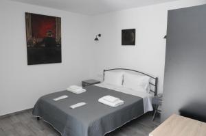 a bedroom with a bed with two towels on it at Bellelen Apartments - Vassilikos in Korinthos