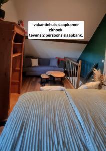 a bedroom with a bed and a table and a couch at 1x Luxe trekkershut of 1x vrijstaand vakantiehuisje Peperkamp in Zelhem