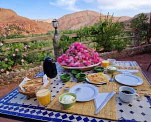 a picnic table with food and flowers on it at Kasbah Chems in El Kelaa des Mgouna