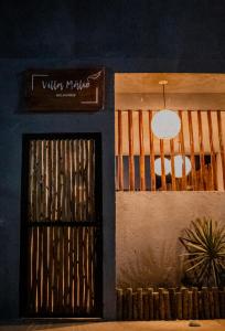 eine Tür zu einem Gebäude mit einem Schild darüber in der Unterkunft Vila Malie milagres in São Miguel dos Milagres