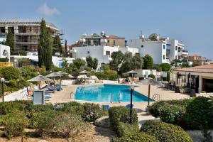 a swimming pool with umbrellas and chairs and buildings at EDEN-Perfect Location, Sea View, Stylish Apartment in Paphos City