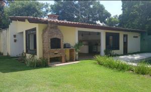 a small house in a yard with a grass at Suíte Santo in Santa Cruz Cabrália