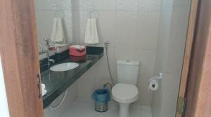 a bathroom with a toilet and a sink at Suíte Santo in Santa Cruz Cabrália +2 photos