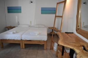 a bedroom with a bed with a ladder and a mirror at Old Mykonos in Drafaki