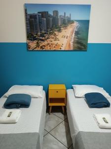 ヴィラ・ヴェーリャにある3 qts na Praia da Costa tudo perto e conforto para criançadaのビーチと建物のある部屋のベッド2台