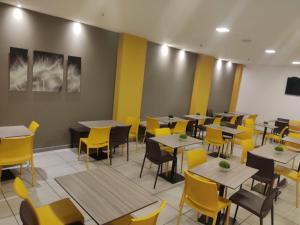 a dining room with tables and yellow chairs at HM HOTEL Expo Inn in Bogotá