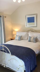 a bedroom with a large bed with a blue blanket at Sea Breeze Cottage on the North Wales Coast in Penrhyn Bay