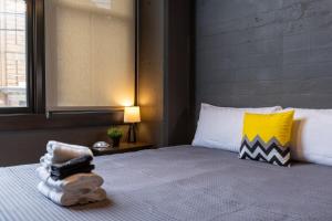 a bedroom with a bed with a yellow and white pillow at Heart of Strip District - King Bd - Rooftop and Gym in Pittsburgh