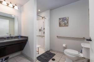a bathroom with a toilet and a sink and a mirror at Heart of Strip District - King Bd - Rooftop and Gym in Pittsburgh +33 photos