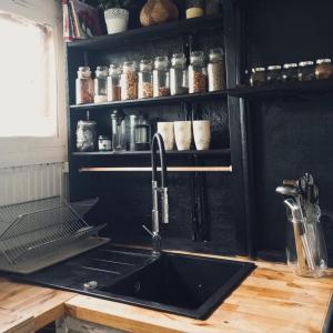 a kitchen with a sink and a counter with a shelf at Cozy cottage 30 min from Tallinn in Laitse