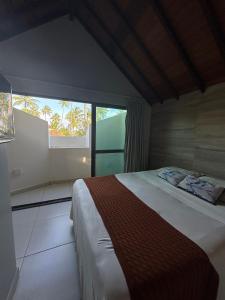 a bedroom with a bed and a large window at Bangalo Luxo Praia dos Carneiros Beach Resort in Praia dos Carneiros +36 photos