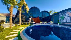 a house with a swimming pool in front of a building at Qafqaz Rolling Bungalow in Gabala