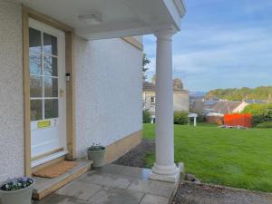 un porche de una casa con una puerta blanca en Spacious 2-bed with Free Parking, en Inverness