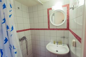 bagno bianco con lavandino e specchio di Sunshine Resort a Lassi