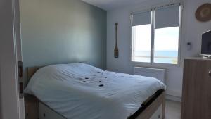 una camera con letto bianco e vista sull'oceano di Appartement cosy en bord de mer a Les Lecques