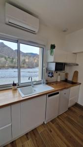 a kitchen with a sink and a large window at Au bord de la rivière in Digne-les-Bains