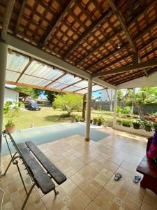 eine Terrasse mit einer Bank unter einer hölzernen Pergola in der Unterkunft Casa Pena - Aluguel por temporada in Salvaterra