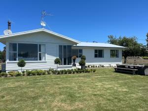 a white house with a lawn in front of it at Wineries and cycle tracks on your doorstep in Havelock North