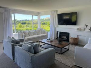 a living room with two couches and a fireplace at Wineries and cycle tracks on your doorstep in Havelock North