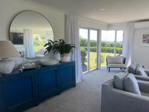 a living room with a blue dresser and a mirror at Wineries and cycle tracks on your doorstep in Havelock North