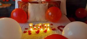 a bed with red balloons and a love sign on it at Boresta House -Santa Elena con vista al Bosque y terraza privada in Medellín