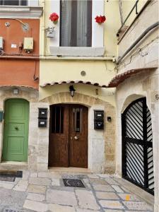 a building with green and brown doors and a window at More Apartments Blue Arch suite in Bari