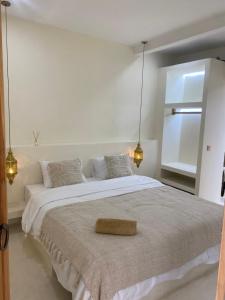 a white bedroom with a large bed with a brown pillow on it at villa Noham canggu 5mn beach in Canggu