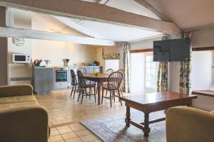 een keuken en woonkamer met een tafel en stoelen bij Gîtes du Château de Meux in Meux