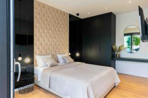 a bedroom with a white bed and a black wall at Villa Marco Polo , grijani bazen , jacuzzi in Bast +53 photos