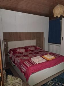 a bedroom with a bed with a red comforter at Appartamento Valeriana in Incudine
