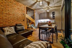a living room with a couch and a brick wall at Wzgórza Jordanowskie in Jordanów