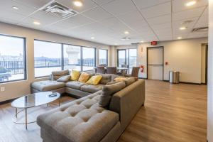 un soggiorno con divani, tavolo e finestre di Steps 2 Everything! - KING Bed - Amazing Roof and Gym a Pittsburgh