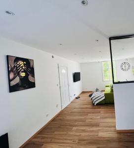 a living room with white walls and wooden floors at Magnifique appartement in Faverolles-sur-Cher