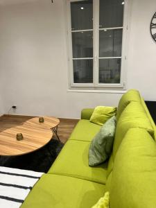 a green couch in a living room with a table at Magnifique appartement in Faverolles-sur-Cher