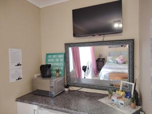 a mirror sitting on a counter in a room at Swartbessie Geusthouse in Krugersdorp +2 photos